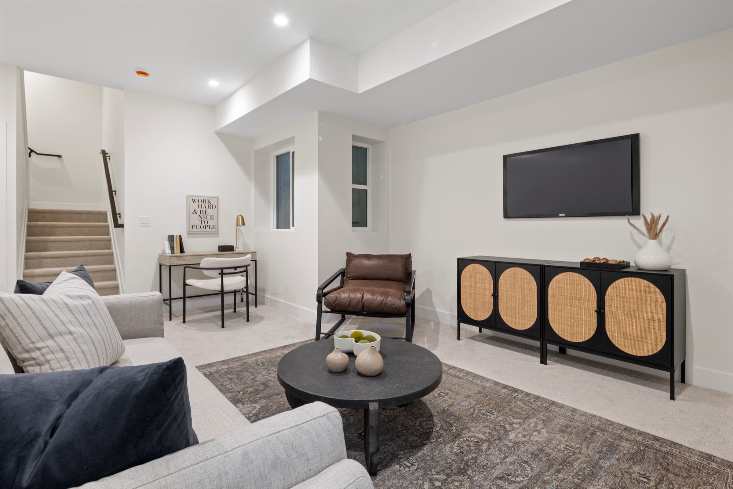 Lower level lounge with built-in cabinetry and a wall-mounted screen
