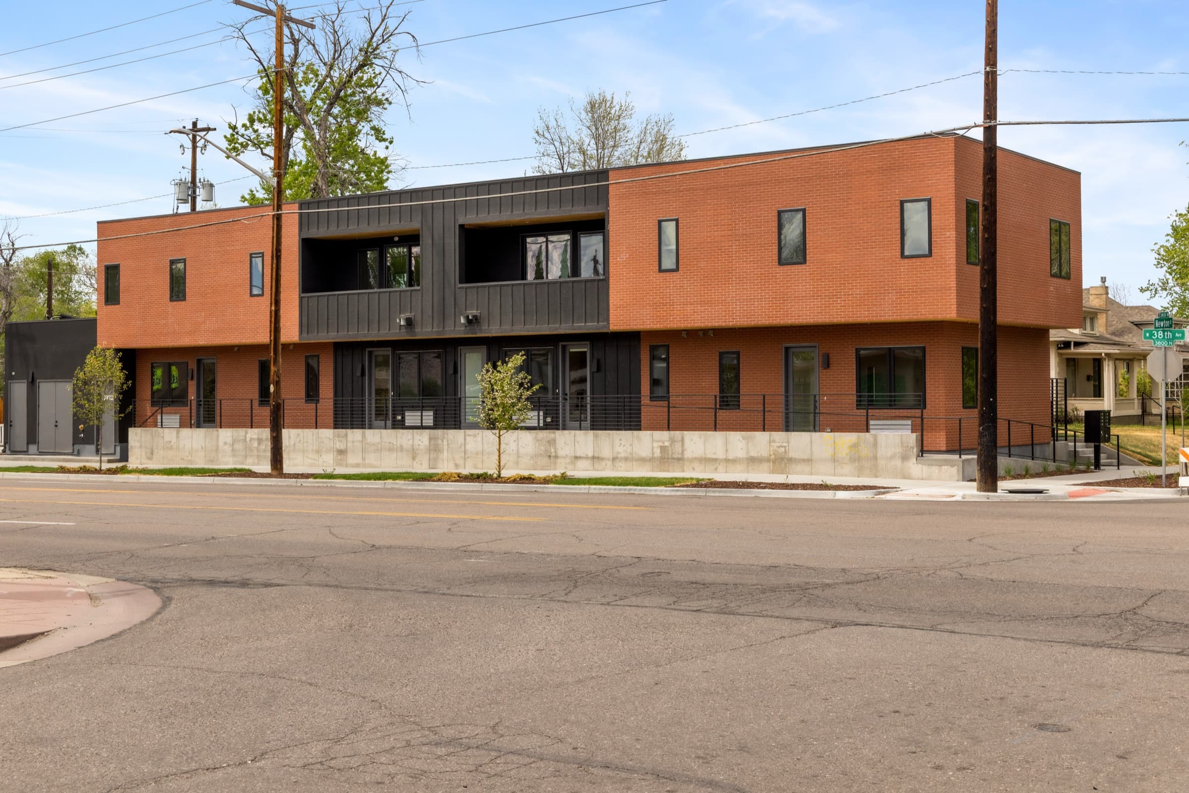 Rust-orange and black multi-unit building from the street